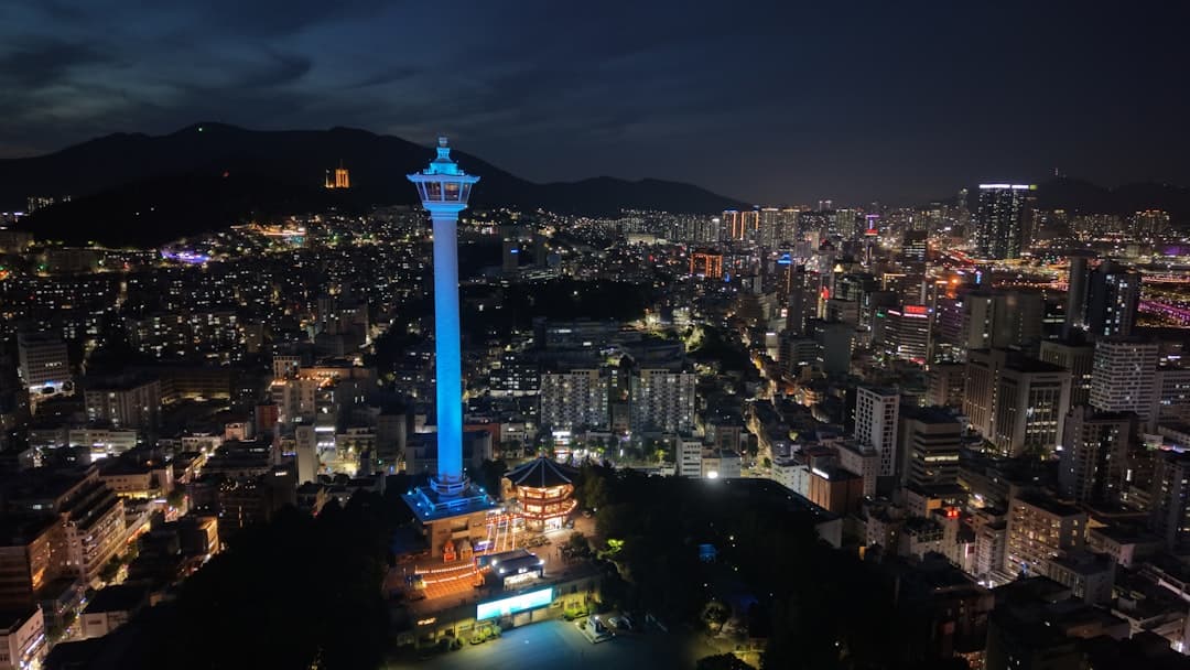 Night view of a city with a glowing blue tower